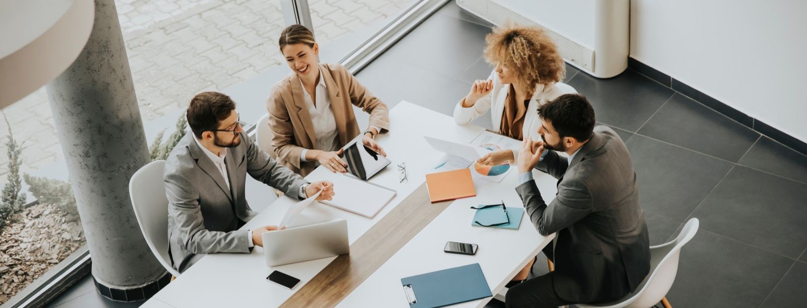 group of 4 professionals sitting at a table having a meeting